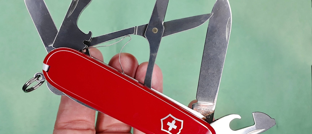 nahaufnahme einer hand die ein aufgeklapptes taschenmesser hält.