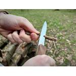 Die Klinge des Victorinox Ranger Wood 55 wird zum Schneiden eines kleinen Holzstocks verwendet. Beide Hände führen das Messer.