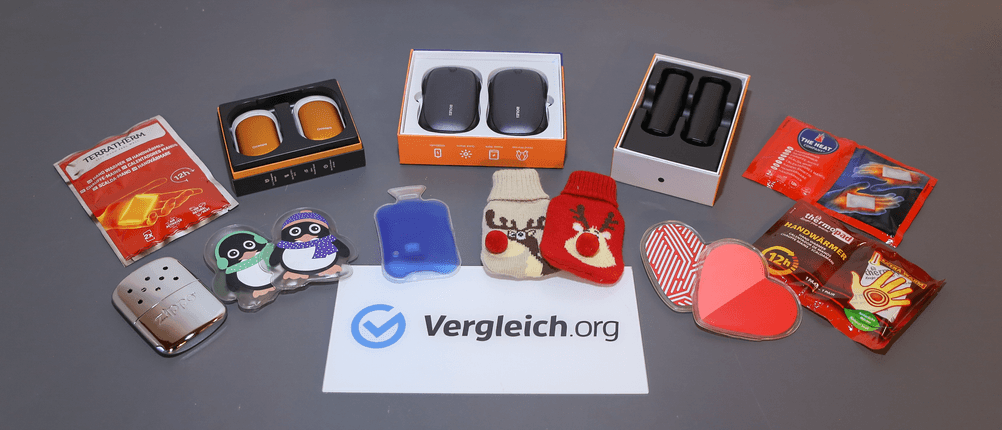Taschenwärmer-Test: Elf getestete Taschenwärmer liegen nebeneinander auf einem Tisch.