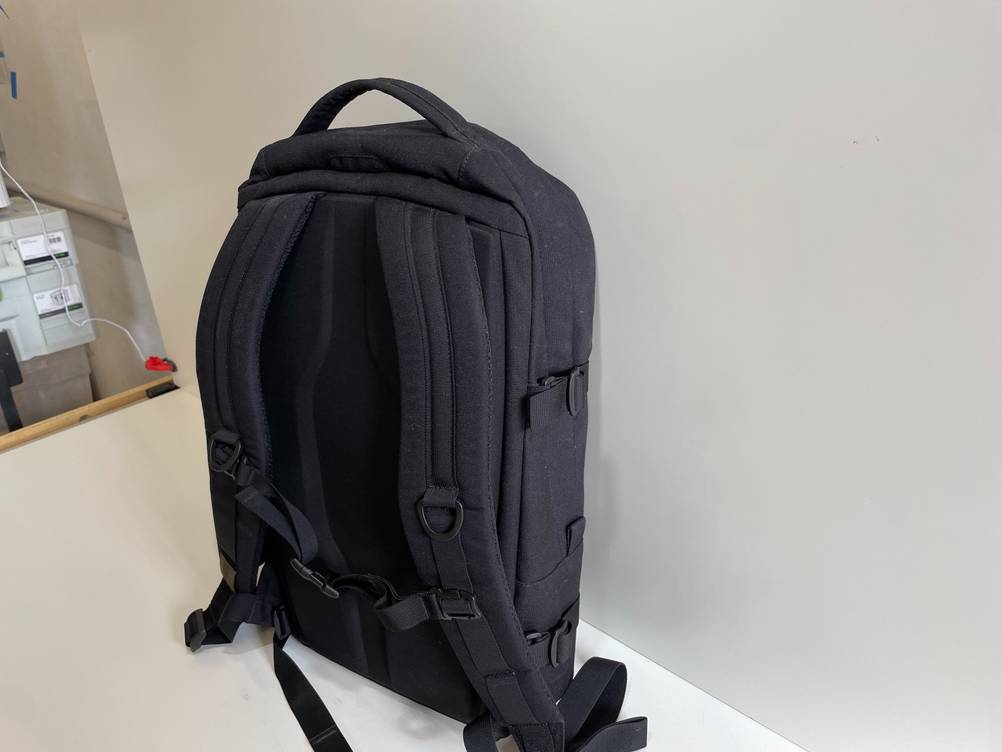 Rückansicht mit Gurten eines getesteten Werkzeugrucksacks, der auf einem weißen Boden steht.
