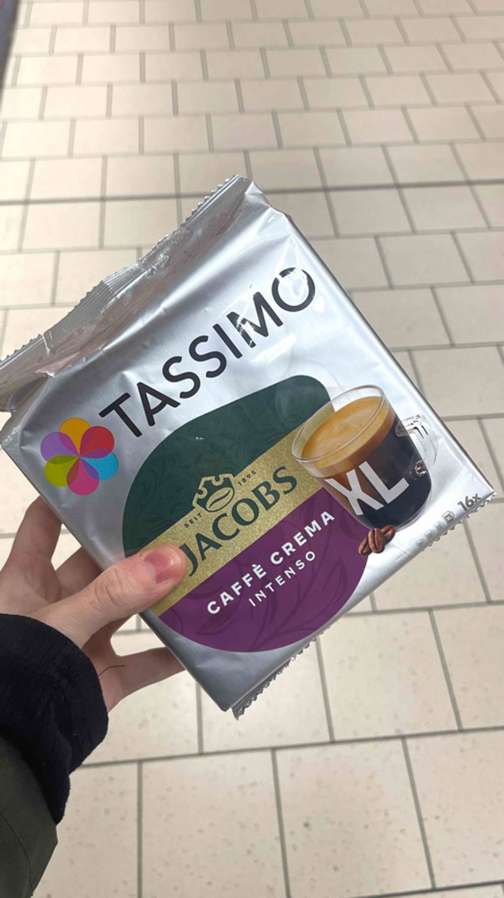 Eine Hand hält die Frischhaltepackung inklusive der getesteten Tassimo-Kapseln in der Ausführung „Intenso“ für die Zubereitung von XL-Kaffeetassen.