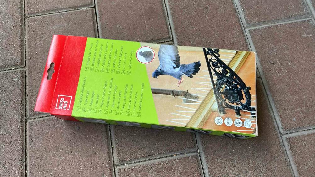 Rückseite der Originalverpackung einer Taubenabwehr im Test auf einem Steinboden.