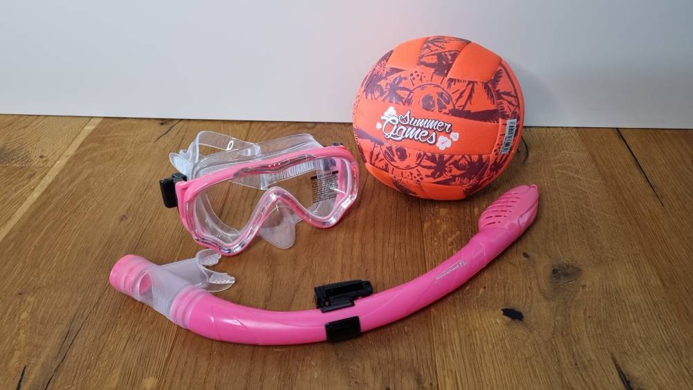 Taucherbrille, Schnorchel und ein Ball liegen auf dem Boden