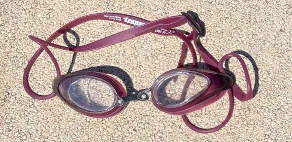 Taucherbrille im Test: dunkelrotes Modell liegt auf einem hellen Boden.