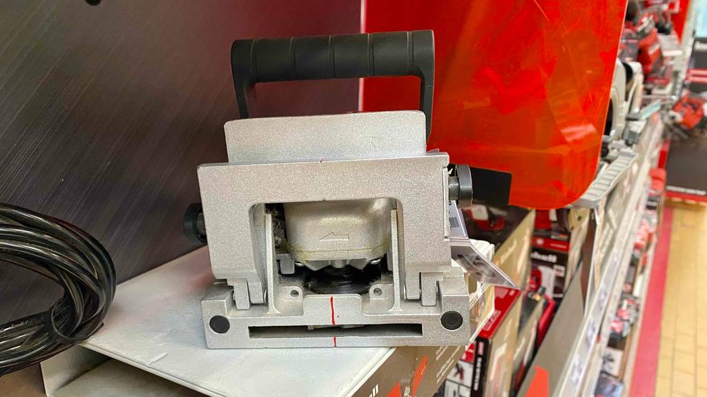 Detailansicht des metallfarbenen integrierten Winkelanschlags einer Flachdübelfräse im Test, die ausgestellt in einem Geschäft steht.