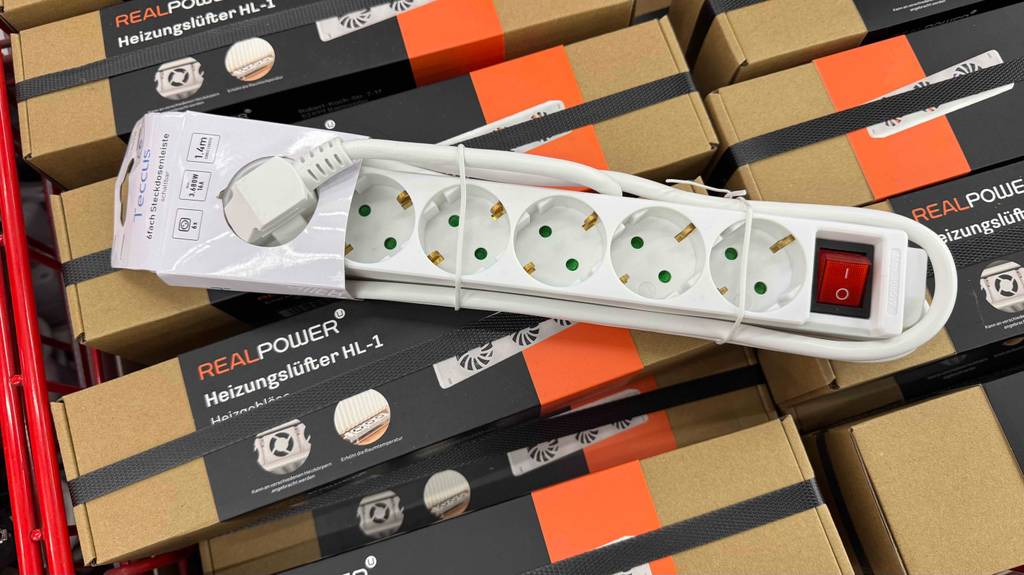 Eine 6-Fach-Steckdosenleiste im Test liegt auf mehreren Verpackungen Heizlüfter.
