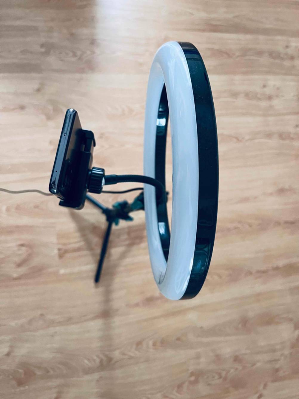 Ein Ringlicht im Test inklusive auf einem Stativ fixierten Smartphone von oben betrachtet.
