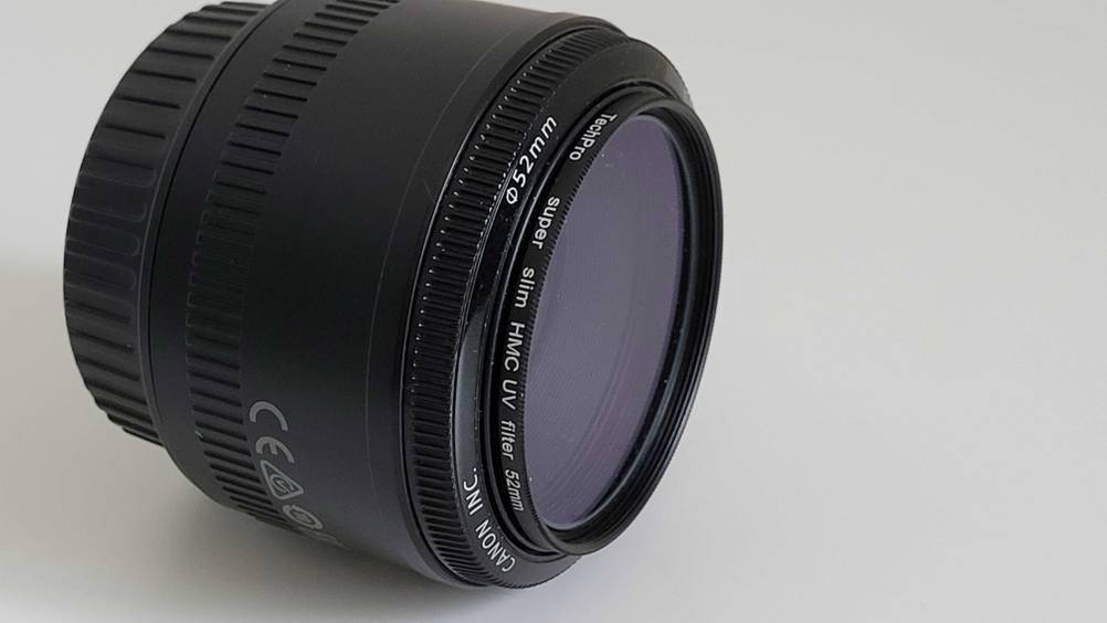 An einem Canon-Objektiv befindet sich aufgeschraubt ein UV-Filter im Test.