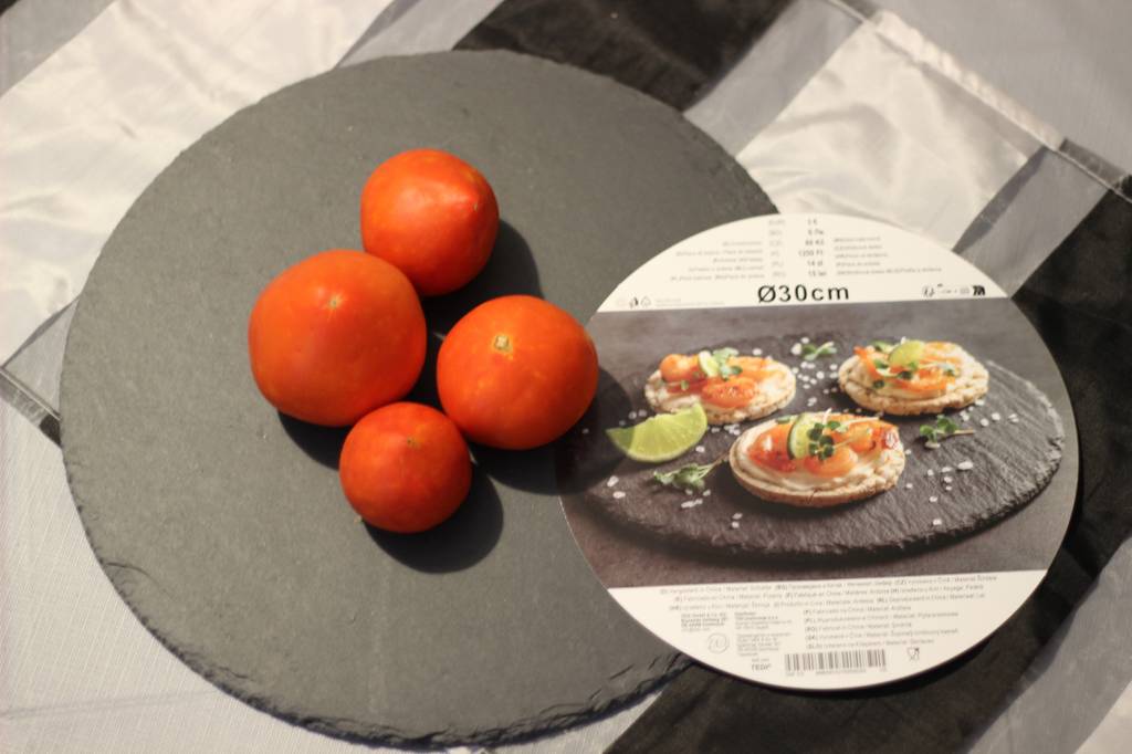 Auf einer Schieferplatte im Test liegen Tomaten.