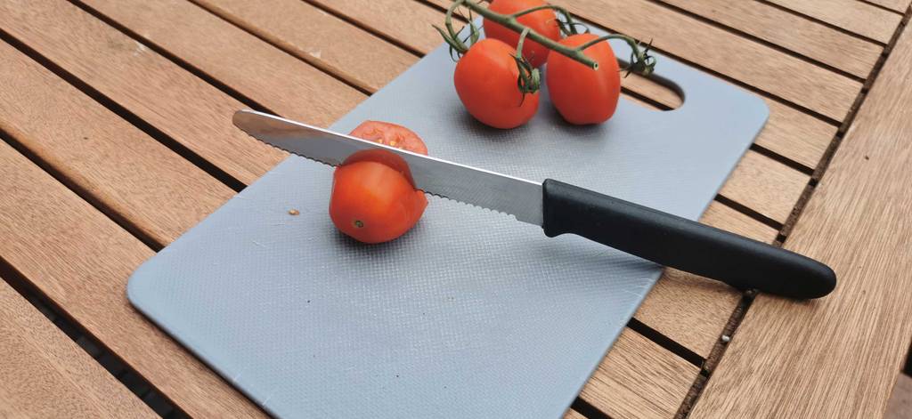 tomatenmessser-test: Gesamtansicht eines in einer Tomate steckenden Tomatenmessers im Test.