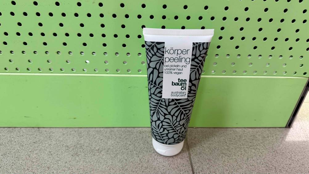 Vor einer grünen Wand befindet sich eine Tube des getesteten Teebaumöl-Duschgels.