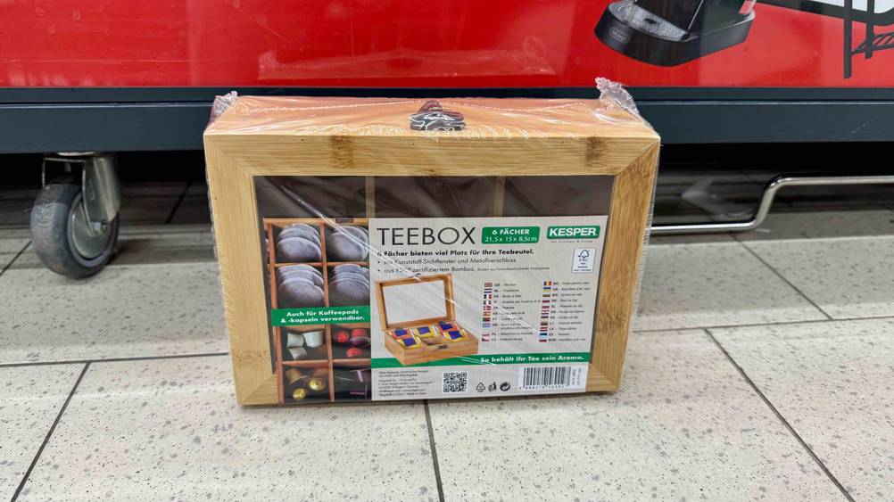 Eine getestete Teebox auf dem Boden vor einem Rollwagen.