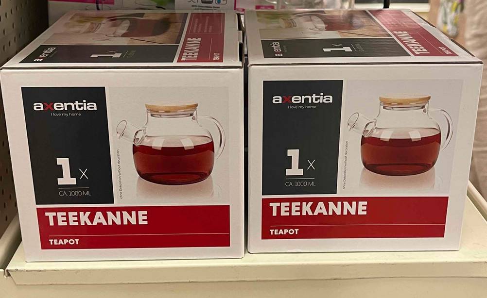 Mehrere verpackte Teekannen aus Glas stehen zum testen in einem Regal.