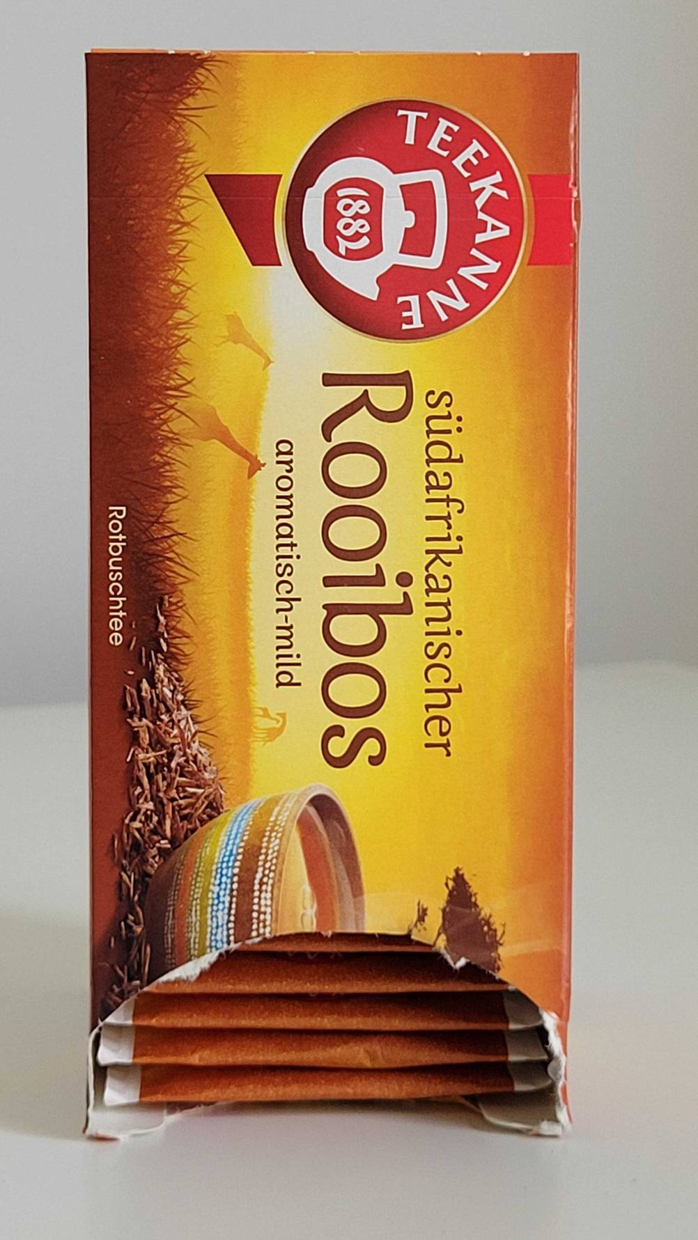 Rooibos-Tees im Test: Eine Verpackung mit Teebeuteln von Teekanne steht auf einer weißen Oberfläche.