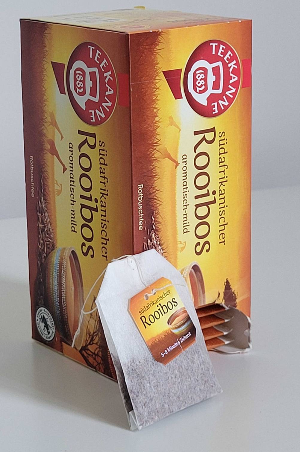 Rooibos-Tee-Test: Vor einer Verpackung mit Teebeuteln der Marke Teekanne steht ein ausgepackter Teebeutel.