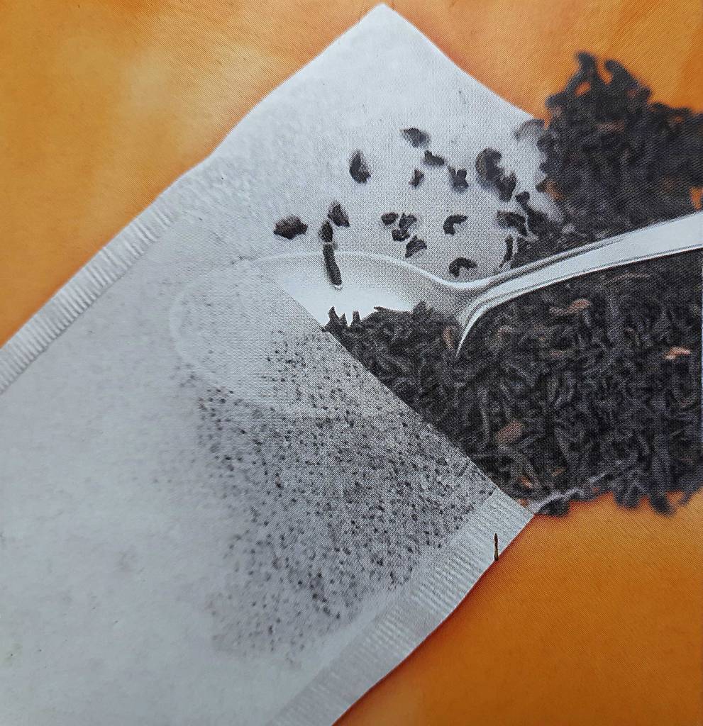 Nahaufnahme der Abbildung auf der orangen Verpackung, die einen Löffel inklusive Tee darstellt, der in den Teebeutel im Test gefüllt wird.