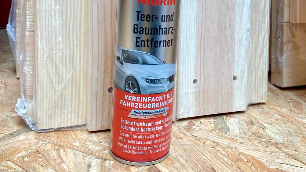 Nahaufnahme der Informationen auf einer Dose des getesteten Teerentferners auf einer Holzfläche.