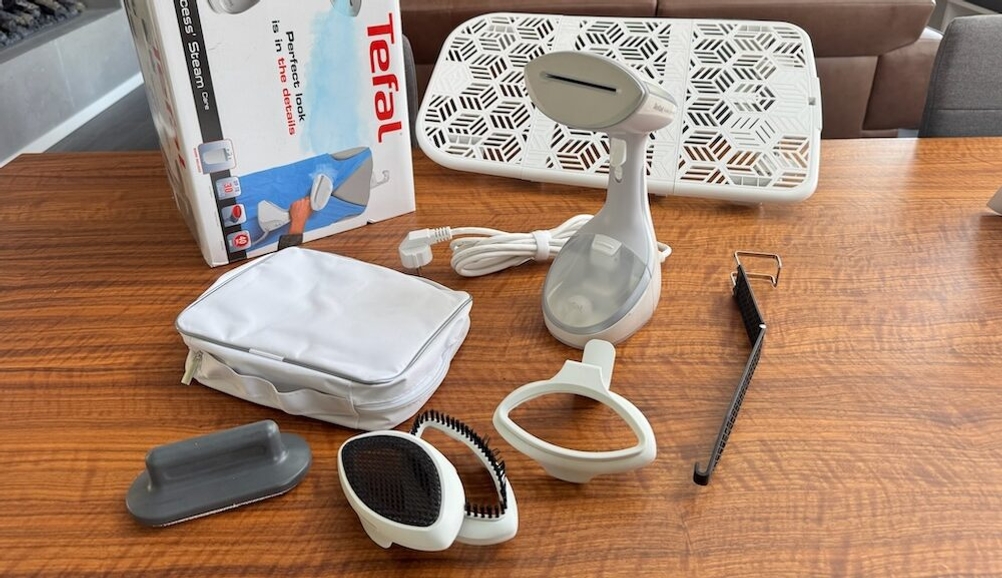 Der Tefal-Dampfglätter liegt samt Zubehör auf einem Tisch.