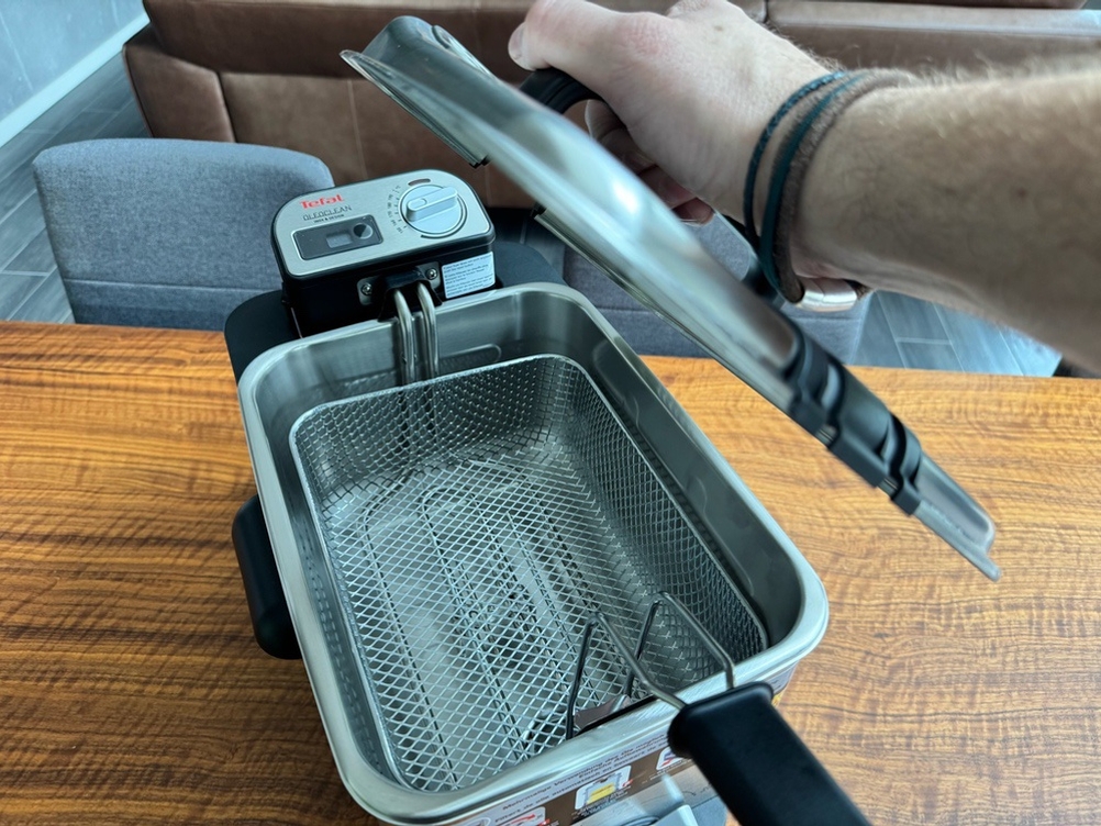 Eine Hand hebt den Deckel der Tefal ‎FR8040 ab