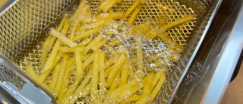 Im Korb der Tefal ‎FR8040 liegen während des Frittierens Pommes