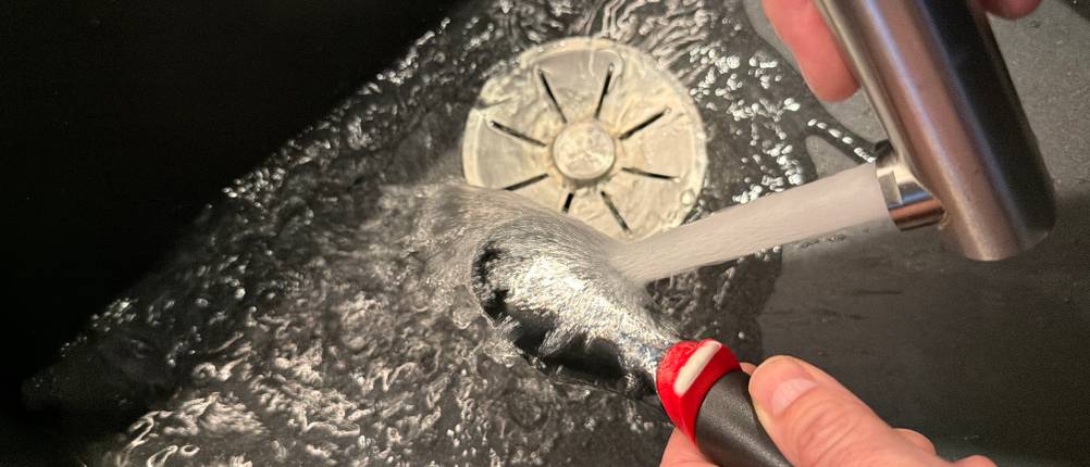 Der Tefal-Ingenio-Eisportionierer wird unter fließendem Wasser gereinigt