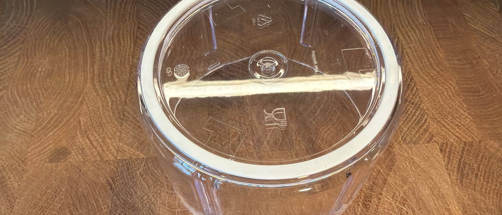 Der Behälter des Tefal K13304 steht auf einem Holzbrett.