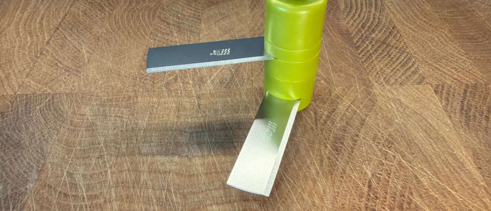 Das Messer des Tefal K13304 steht auf einem Holzbrett.