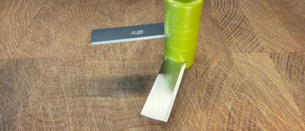 Das Messer des Tefal K13304 steht auf einem Holzbrett.