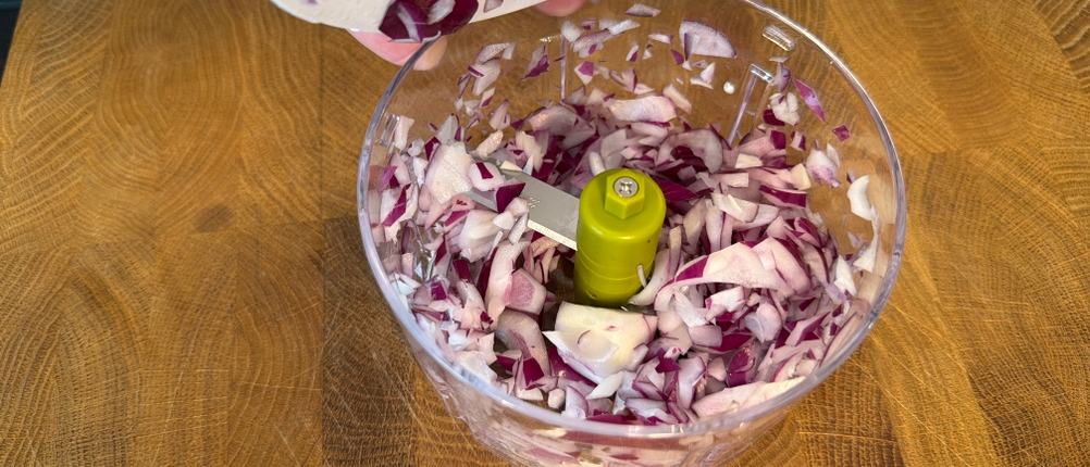 Im Behälter des Tefal K13304 befinden sich Zwiebelstücke.