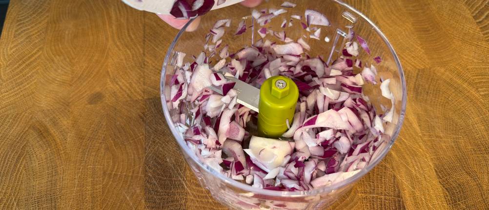 Im Behälter des Tefal K13304 befinden sich Zwiebelstücke.