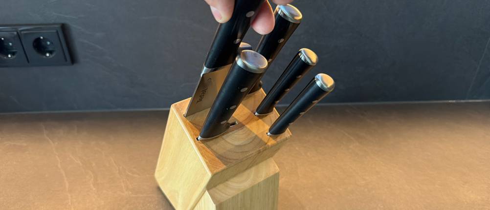 Eine Hand zieht ein Messer aus dem Messerblock des Tefal K232S574.