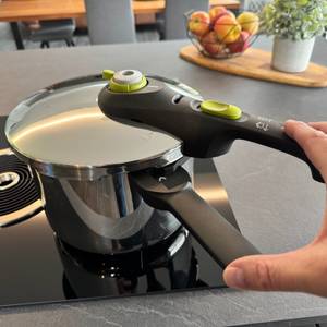 Eine Hand verriegelt den Deckel des Tefal P2530737.