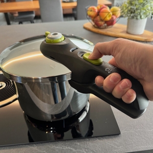 Eine Hand hält den Deckel des Tefal P2530737 am Griff fest.