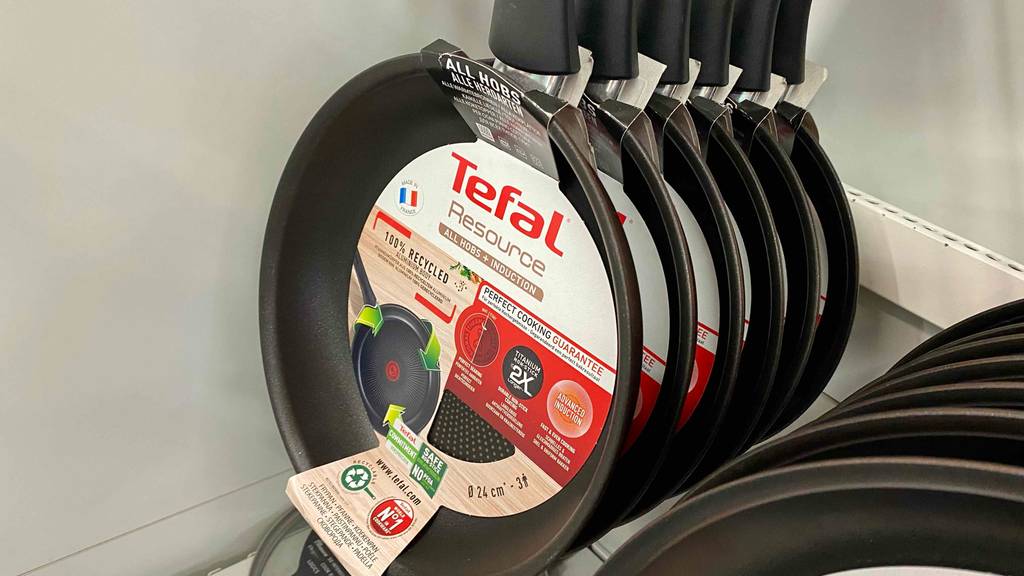 Tefal-Pfanne getestet: mehrere Pfannen von Tefal hängen an einem Verkaufsstand hinter- und nebeneinander.