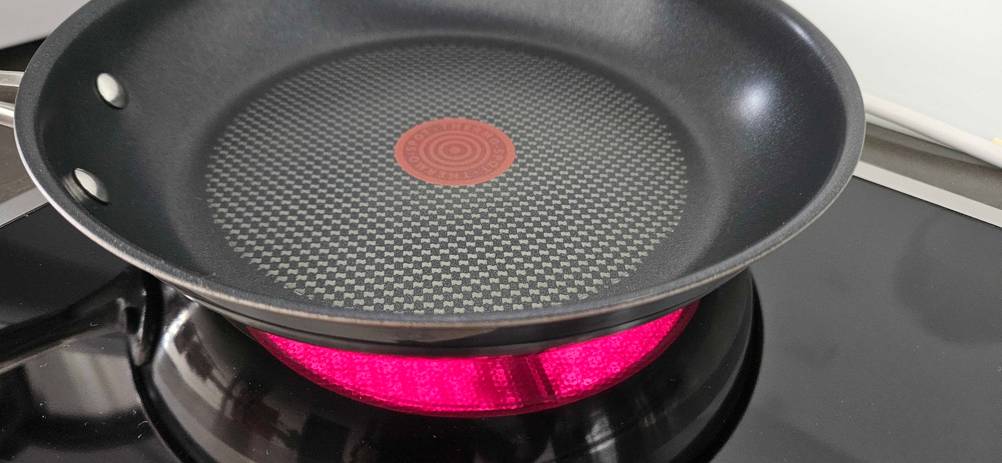 Eine Tefal-Pfanne steht zum Testen auf einer eingeschalteten Herdplatte.