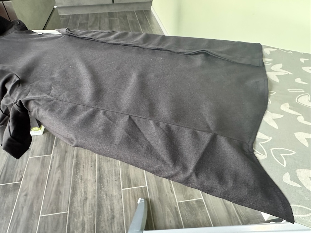 Schwarzes Hemd liegt auf einem Bügelbrett