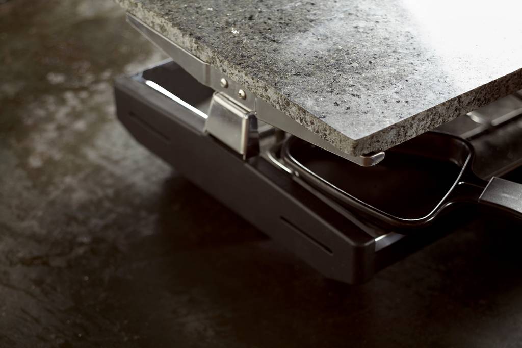 Tefal-Raclette-Test: auf einer dunklen Fläche steht ein Raclette mit Steinplatte.