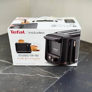 Der getestete Toaster von Tefal steht verpackt auf einer dunklen Arbeitsfläche.