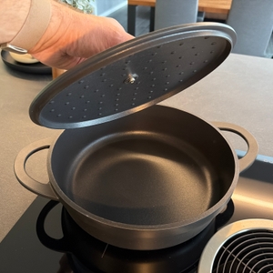 Eine Hand hebt den Deckel von der Tefal-Trattoria-Servierpfanne E21872