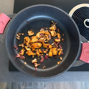 Gebratenes Fleisch und Zwiebeln liegen in der Tefal-Trattoria-Servierpfanne E21872