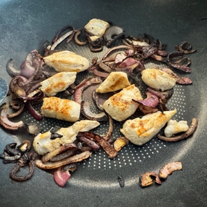 Angebratene Zwiebeln und Hähnchen in Nahaufnahme