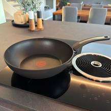 Die Tefal-Wokpfanne Unlimited On steht auf einer Kochplatte