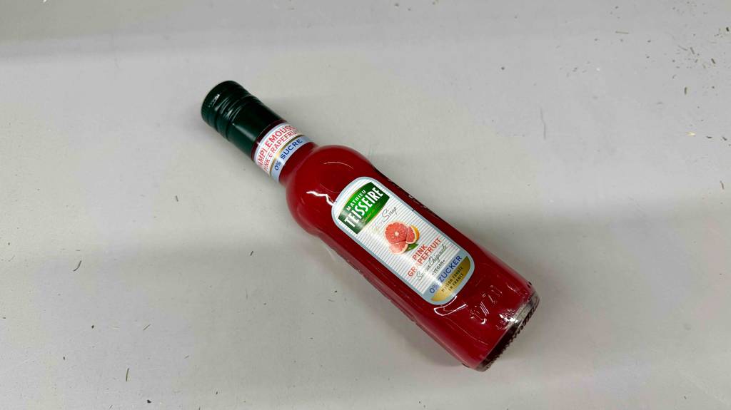 Getestet: Fruchtsirup Pink Grapefruit in der Flasche liegt auf einer weißen Oberfläche.