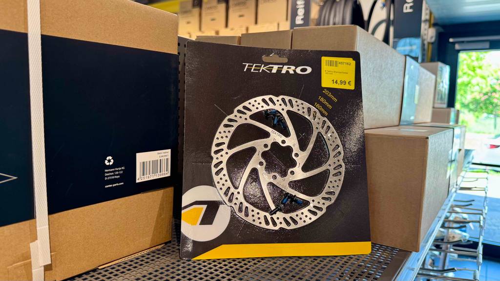 Die Fahrrad-Bremsscheibe im Test innerhalb ihrer Verpackung inklusive Preisetikett steht auf einem Regal im Geschäft.