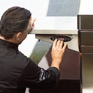 Ein Grillfan tippt die Wunsch-Temperatur in den Regler ein