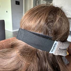 Der Hinterkopf einer Person, die die Tempur-Schlafmaske trägt.