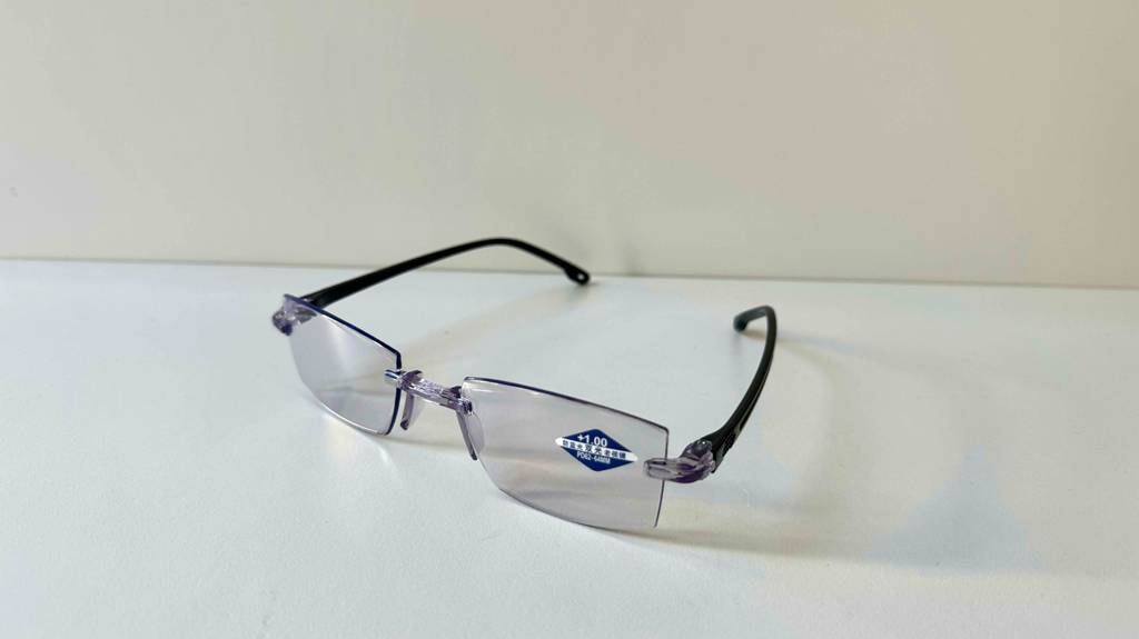 Gleitsichtbrille im Test liegt mit geöffneten Bügeln auf einer weißen Oberfläche.