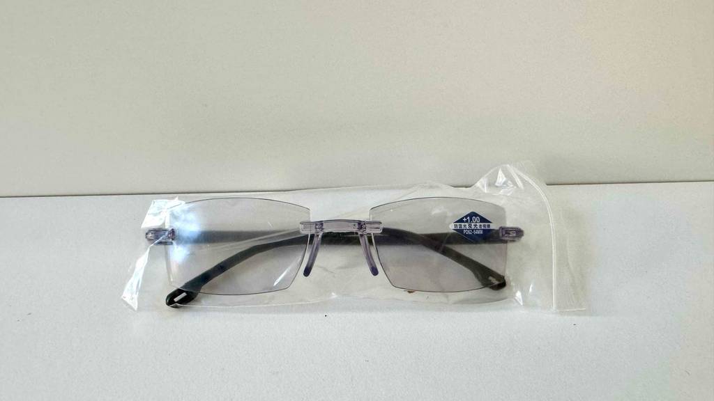 In ihrer transparenten Kunststoffverpackung liegt eine Gleitsichtbrille im Test auf einer weißen Oberfläche.