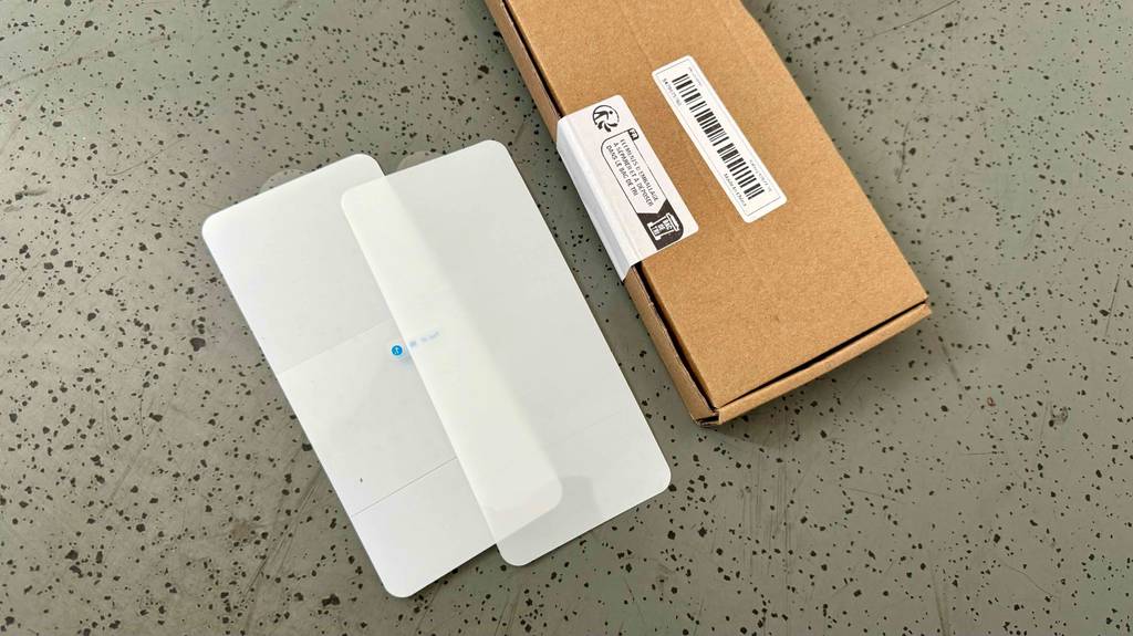 Zwei getestete Samsung-Galaxy-S20-FE-Panzergläser liegen neben ihrem Verpackungskarton.