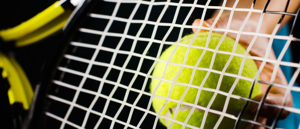 Tennissaiten auf Tennisschläger mit Tennisball